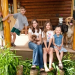 A group of smiling kids, accompanied by their three pets, enjoy their time in their dream home.