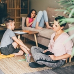 a family of three sitting in the living room