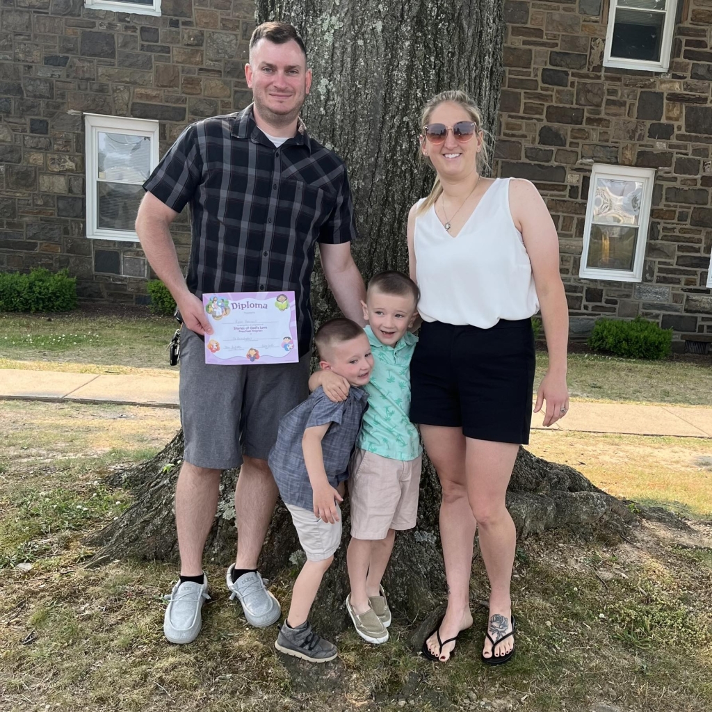 An image of Kait and her husband together with their 2 sons during Pre K4 graduation